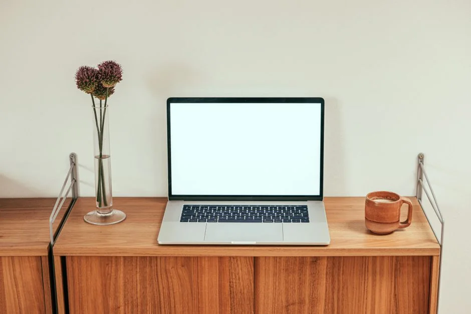 A sleek office desk setup featuring Apple devices: iMac, MacBook, and iPad.