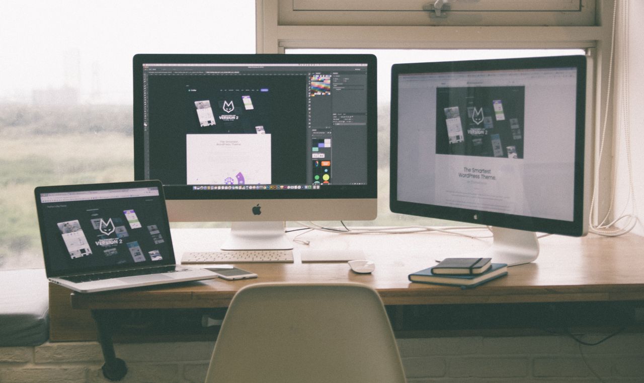 créatif Un espace de travail élégant et performant avec plusieurs écrans, un ordinateur portable et un smartphone, illustrant un projet de design web.